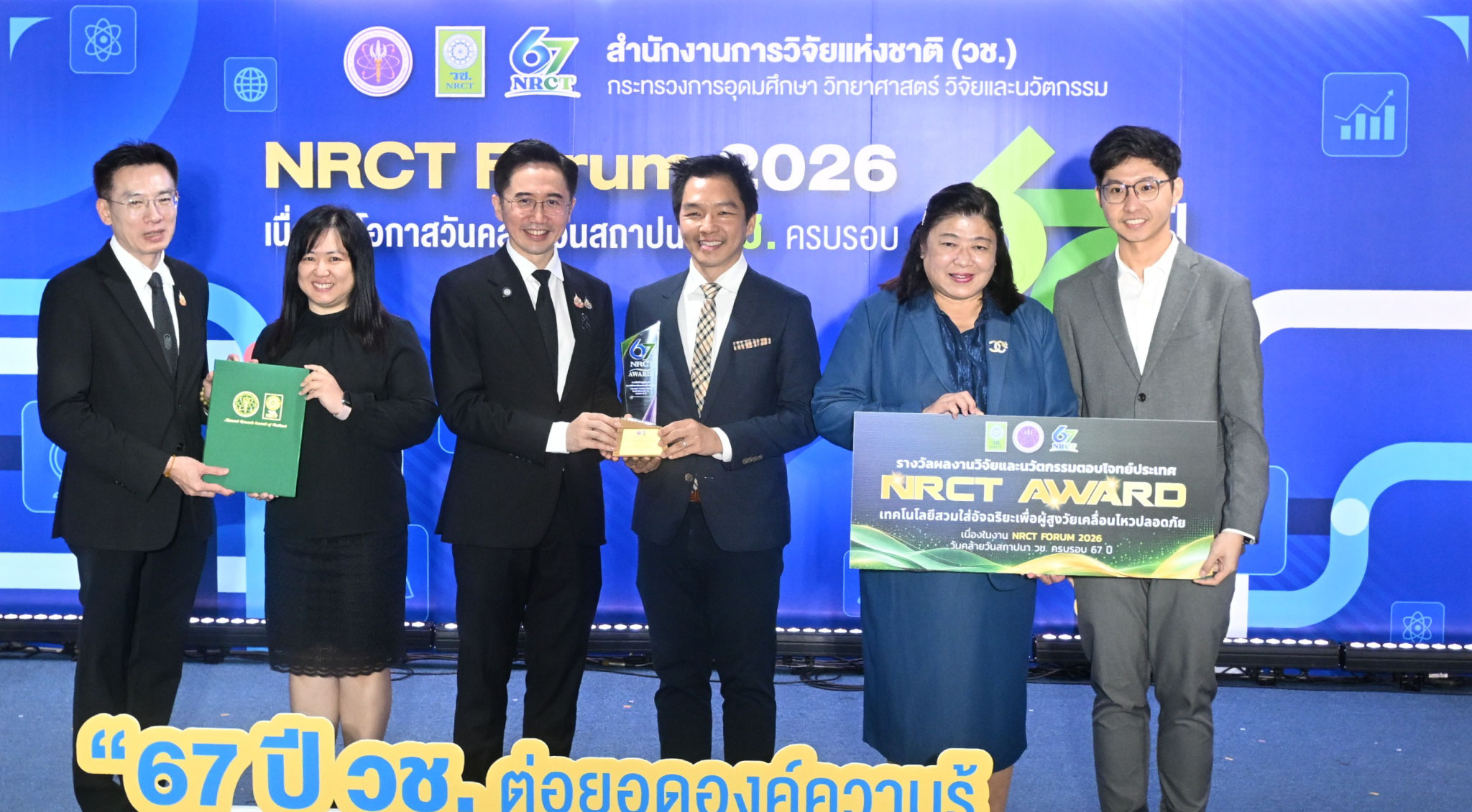 ภาพการรับรางวัล ผลงาน “เทคโนโลยีสวมใส่อัจฉริยะเพื่อผู้สูงวัยเคลื่อนไหวปลอดภัย” นำโดย ดร.ศราวุธ เลิศพลังสันติ พร้อมด้วยคณะวิจัย