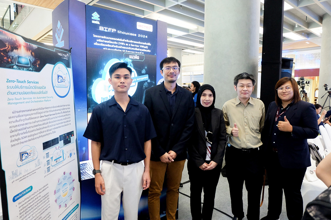 ทีมวิจัยผู้พัฒนา ZeroTouch+ Services ยืนถ่ายภาพร่วมกันหน้าบอร์ดนิทรรศการของแพลตฟอร์ม